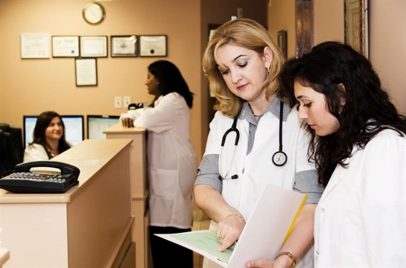 Clinical staff reviewing patient paperwork at an agency front desk